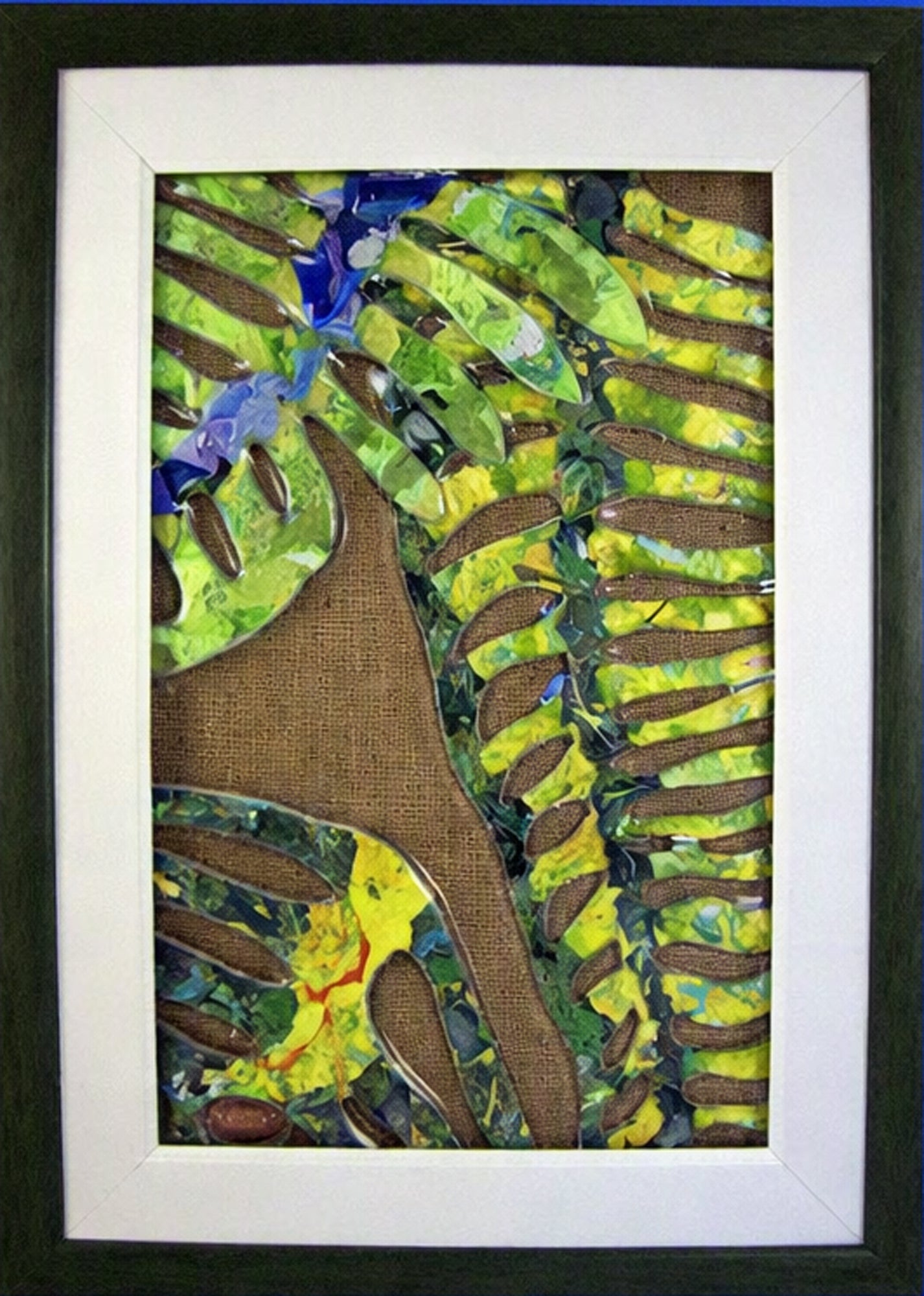 Framed Trapunto Art Glass featuring textured green and yellow leaf-like patterns, brown organic shapes, and blue accents, set within a white mat and dark frame.