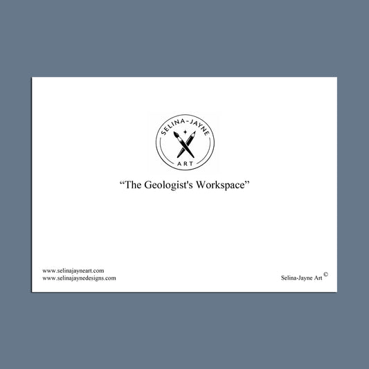 A white rectangular print or card centered on a muted blue-gray background, featuring the circular Selina-Jayne Art logo and the text “The Geologist’s Workspace” with website text along the bottom.