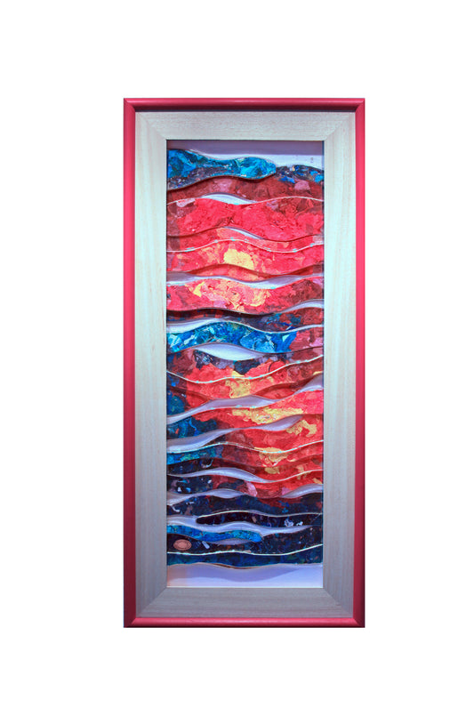 A framed Trapunto Art Glass featuring wavy, layered patterns in vibrant red, blue, and gold, enclosed in a wooden frame with a red outer border, set against a plain white background.