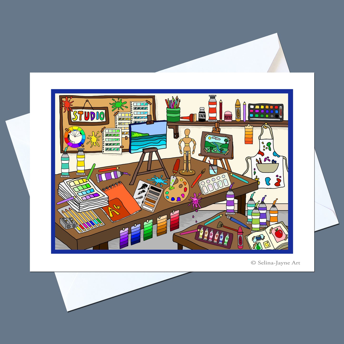 A white art print card featuring a colorful cartoon illustration of a creative artist studio, shown with a white envelope on a slate gray background. The print includes the text '© Selina Jayne Art' in the bottom right corner.