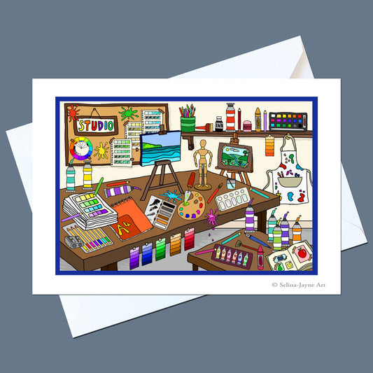A white art print card featuring a colorful cartoon illustration of a creative artist studio, shown with a white envelope on a slate gray background. The print includes the text '© Selina Jayne Art' in the bottom right corner.