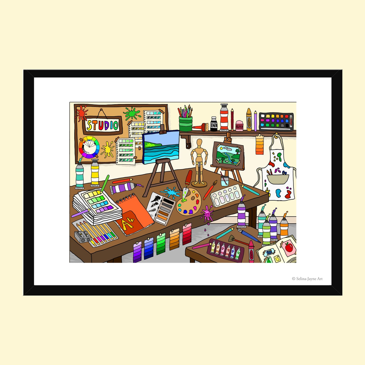 A framed cartoon art studio illustration featuring colorful paint tubes, easels, canvases, brushes, shelves, and an artist's worktable, presented on a light cream background with a black frame.