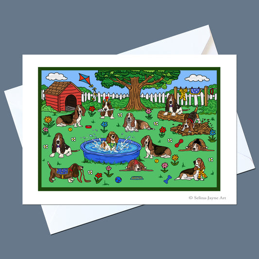 A printed art card featuring a colorful cartoon illustration of basset hounds in a backyard scene with a doghouse, tree, fence, and pool, shown with a white envelope on a gray background.