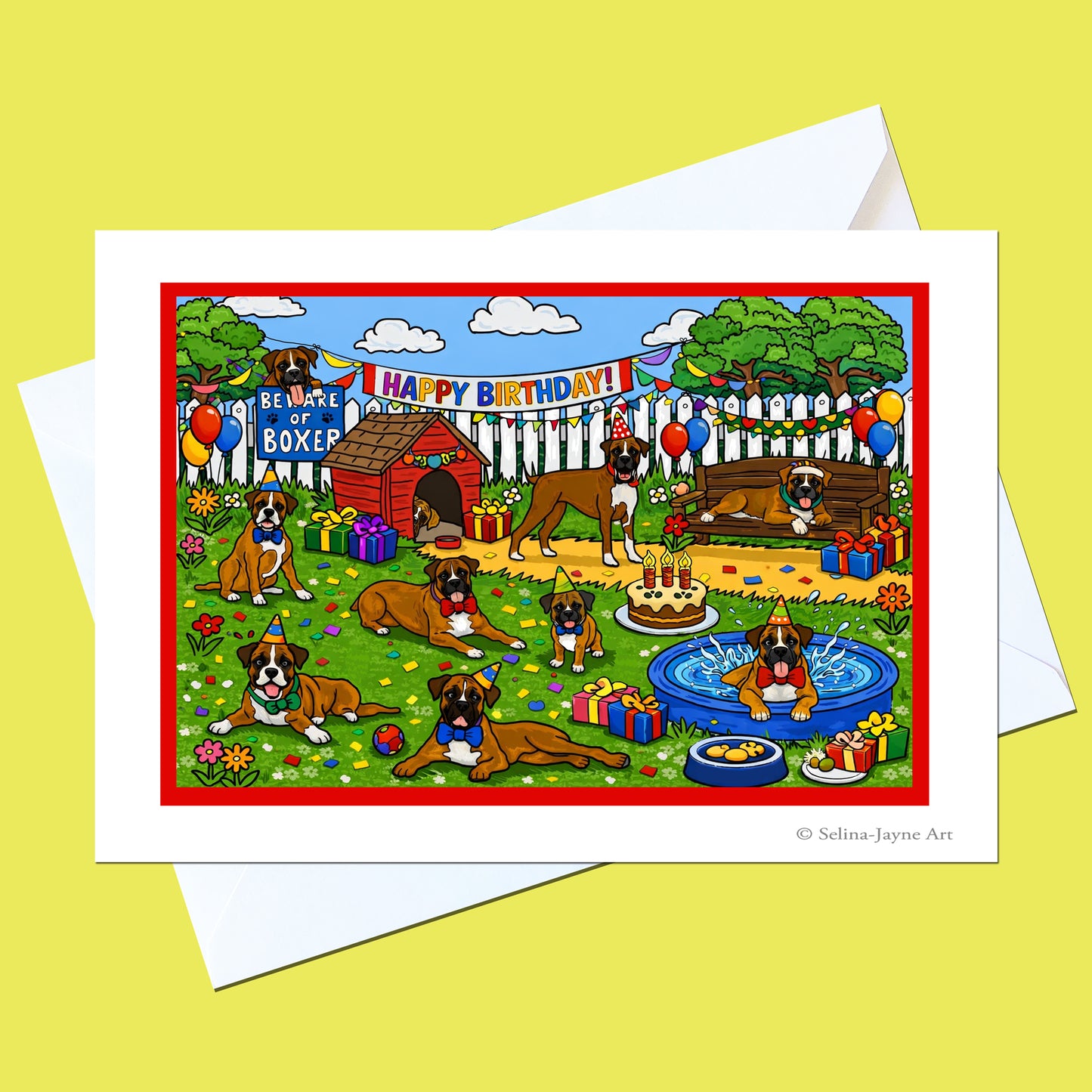 A square greeting card with a white border and white envelope, featuring a colorful cartoon birthday scene with boxer dogs, balloons, gifts, a doghouse, pool, and banners reading 'Happy Birthday' and 'Be a Vase of Boxer.' The card is photographed on a pale yellow background.