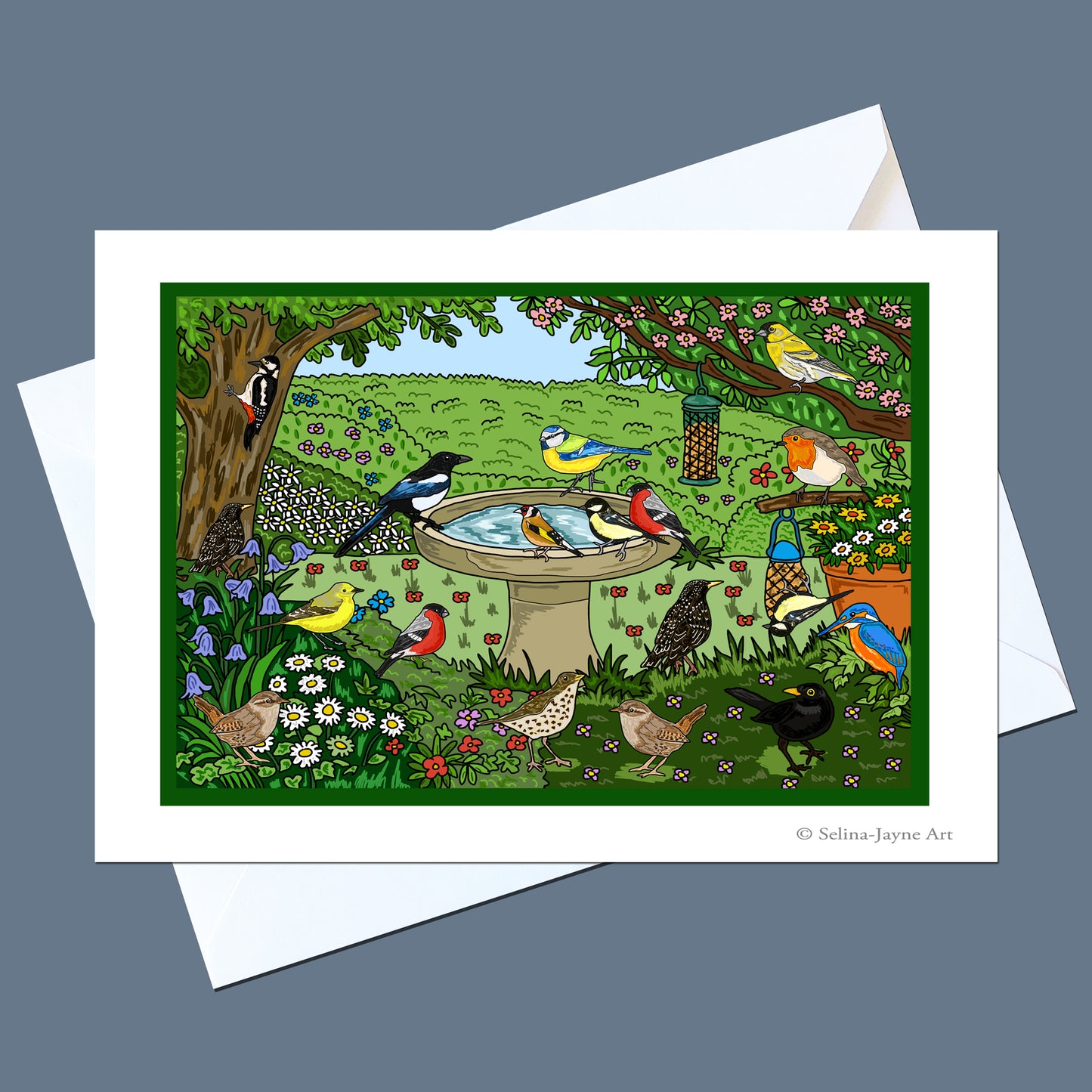 A square art print card featuring a colorful bird garden scene with birds around a birdbath, shown with white envelopes on a slate blue background. The print includes a visible artist signature in the lower right corner.