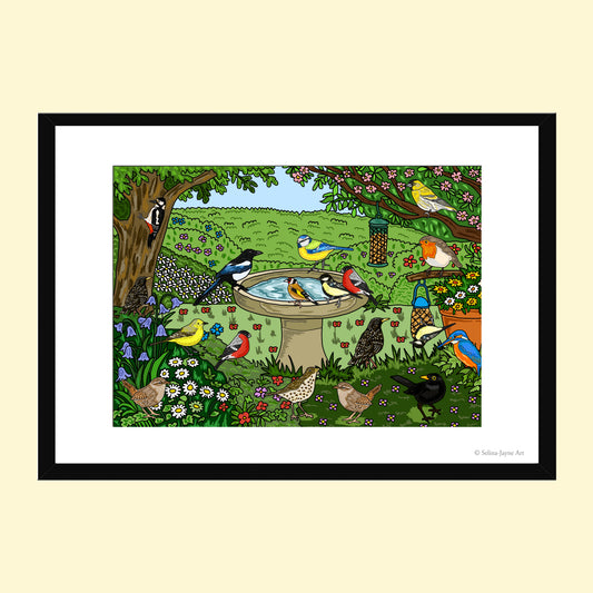 A framed art print featuring a colorful illustration of various birds in a lush garden scene with a birdbath, trees, and flowers, presented on a light cream background.