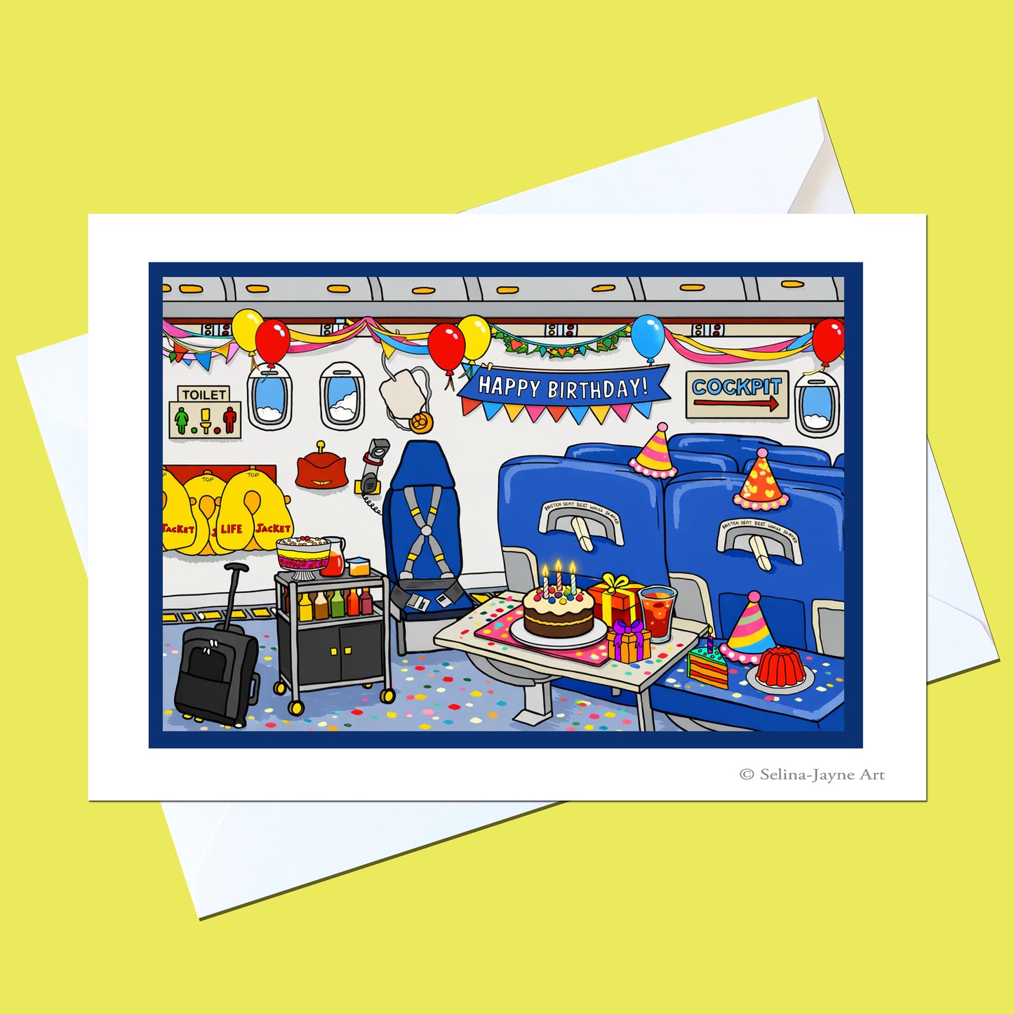 A greeting card featuring a colorful cartoon illustration of a train compartment decorated for a birthday, with blue seats, balloons, a cake, and a waiter. The card is shown with a white envelope on a pale yellow background.