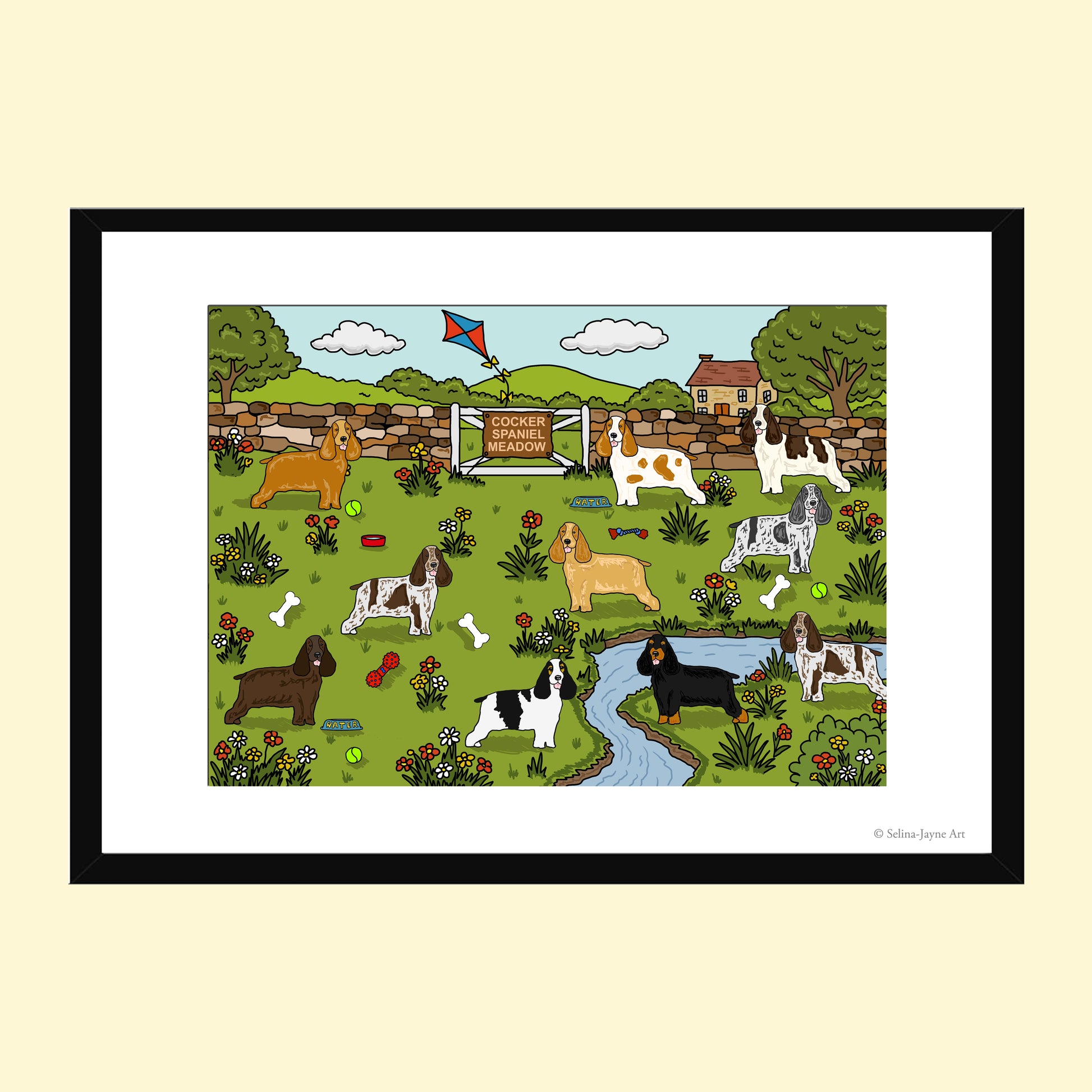A framed art print featuring a whimsical illustration of various dog breeds in a green park with a small stream, stone wall, and a sign reading 'Welsh Corgi Welcome'. The print is presented in a black frame with a white mat against a light beige background.