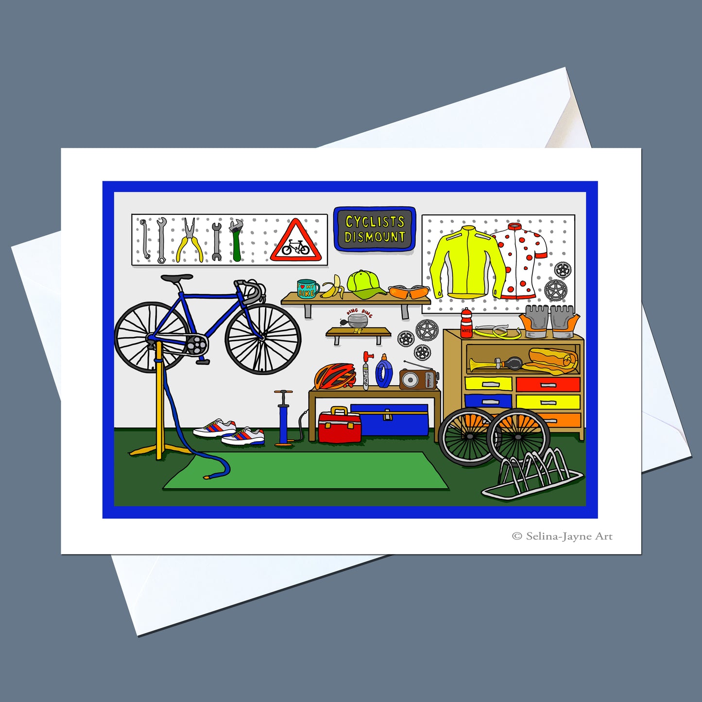 A square art print or greeting card featuring a colorful cartoon bicycle workshop scene, shown with white envelopes on a muted blue-gray background. The illustration includes a blue bicycle on a stand, tools on a wall, a yellow jersey, shelves, and storage cabinets.