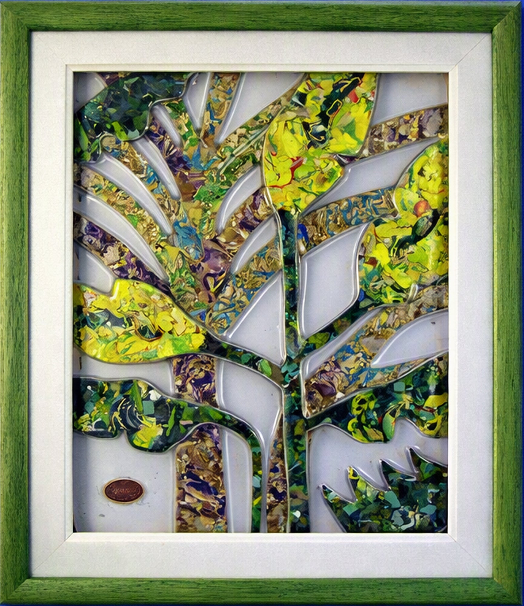 A framed Trapunto art glas depicting a stylised tree with vibrant green, yellow, and blue mosaic leaves and trunk, set within a white mat and a textured green wooden frame.