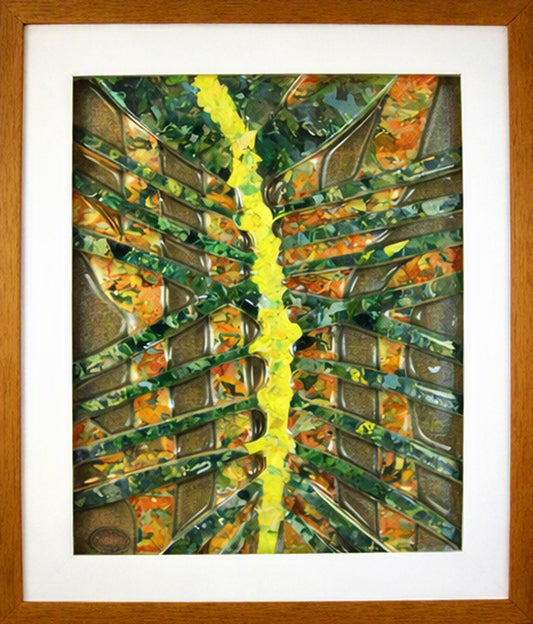 Framed Trapunto Art Glass featuring a central bright yellow vertical streak radiating from the middle, with layered metallic gray and green angular forms and orange accents, set within a white mat and natural wood frame.