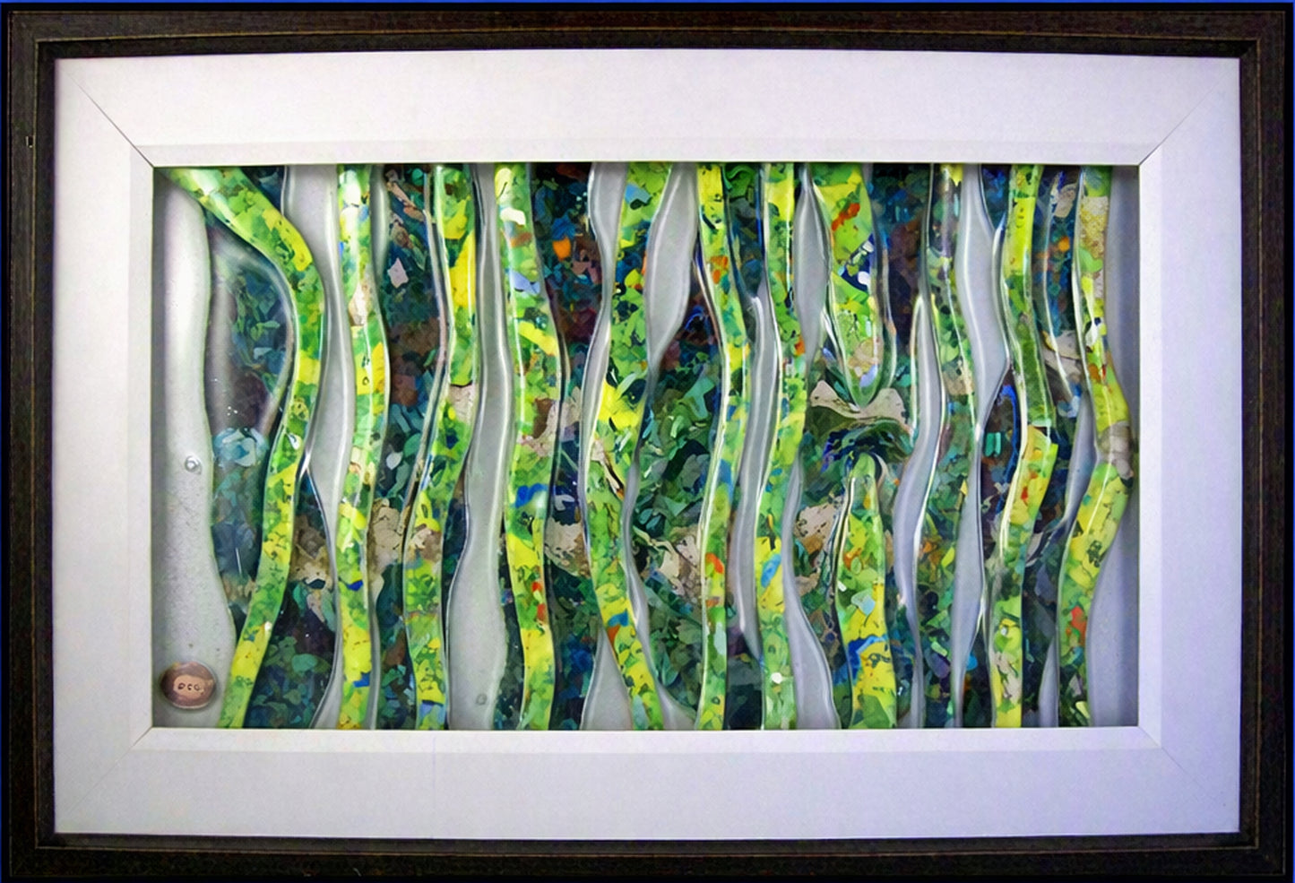 Framed Trapunto Art lass featuring wavy, layered vertical strips in green, yellow, blue, and white, set within a white mat and dark frame.