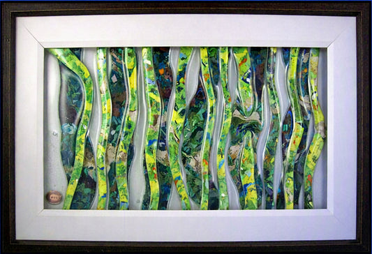 Framed Trapunto Art lass featuring wavy, layered vertical strips in green, yellow, blue, and white, set within a white mat and dark frame.