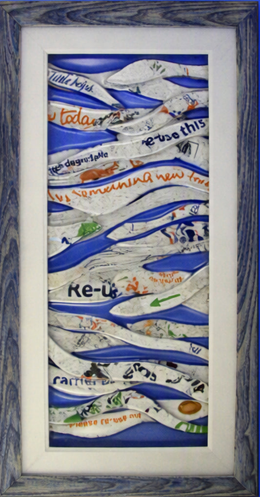 A framed Trapunto Art Glass featuring layered, wavy white paper strips with handwritten text and illustrations over a blue background, set within a white mat and a rustic blue-gray wooden frame.