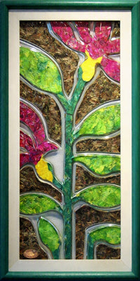 A framed Trapunto Art Glass piece featuring a stylised tree with green leaves, brown trunk details, and pink flowers with yellow centres, enclosed in a dark green frame.