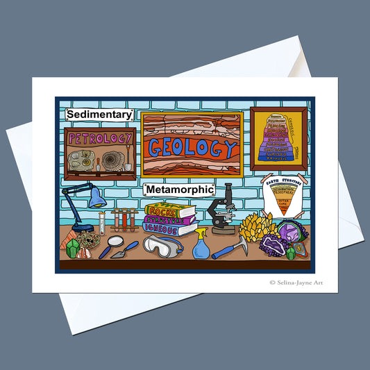 A square art print or card featuring a colorful cartoon illustration of a geology lab, with framed signs reading Sedimentary, Petrology, Geology, and Metamorphic, plus drawings of tools and rocks, shown on top of white envelopes against a muted blue-gray background.