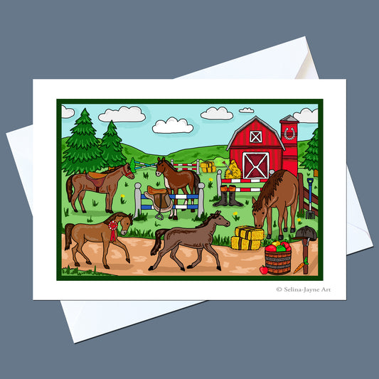 A square art print or greeting card featuring a colorful cartoon farm scene with horses, a red barn, trees, and hay bales, shown on top of white envelopes against a slate blue background. Small text at the bottom right reads '© Selina Jayne Art'.