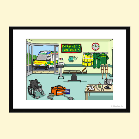 A framed cartoon illustration of an ambulance station scene with an ambulance outside, emergency gear inside, and a sign reading 'PARAMEDIC ON DUTY'. The artwork is shown in a black frame with a white mat on a pale beige background.