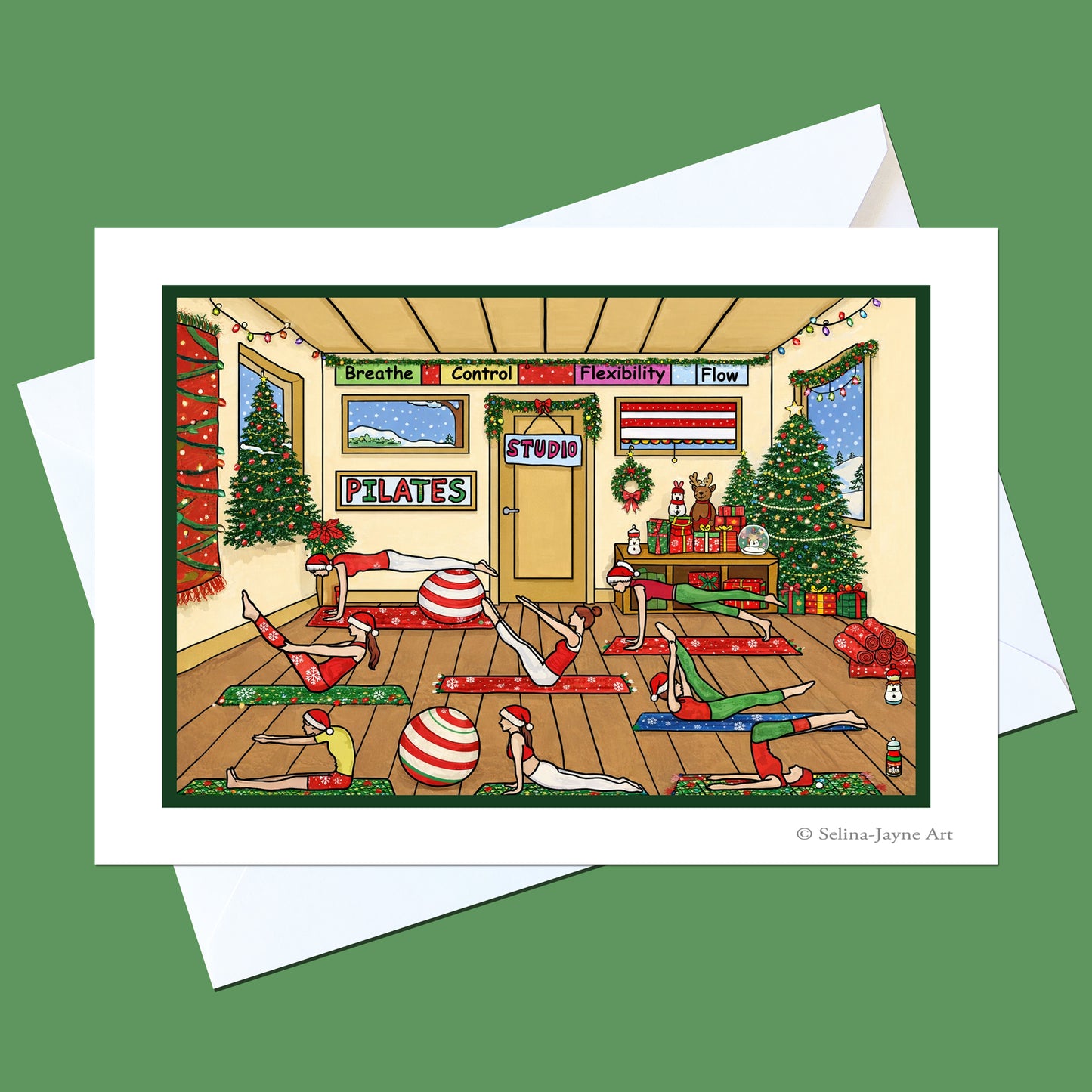 A square art print or card featuring a whimsical illustrated Christmas Pilates studio scene, shown with white envelopes on a solid green background. The illustration depicts people doing Pilates exercises in a decorated room with Christmas trees, ornaments, and signs.
