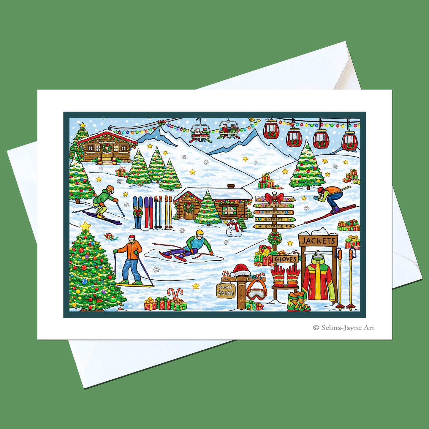 A square art print or card featuring a colorful winter ski village scene with skiers, lifts, cabins, trees, and gift displays, shown with white envelopes on a solid green background.
