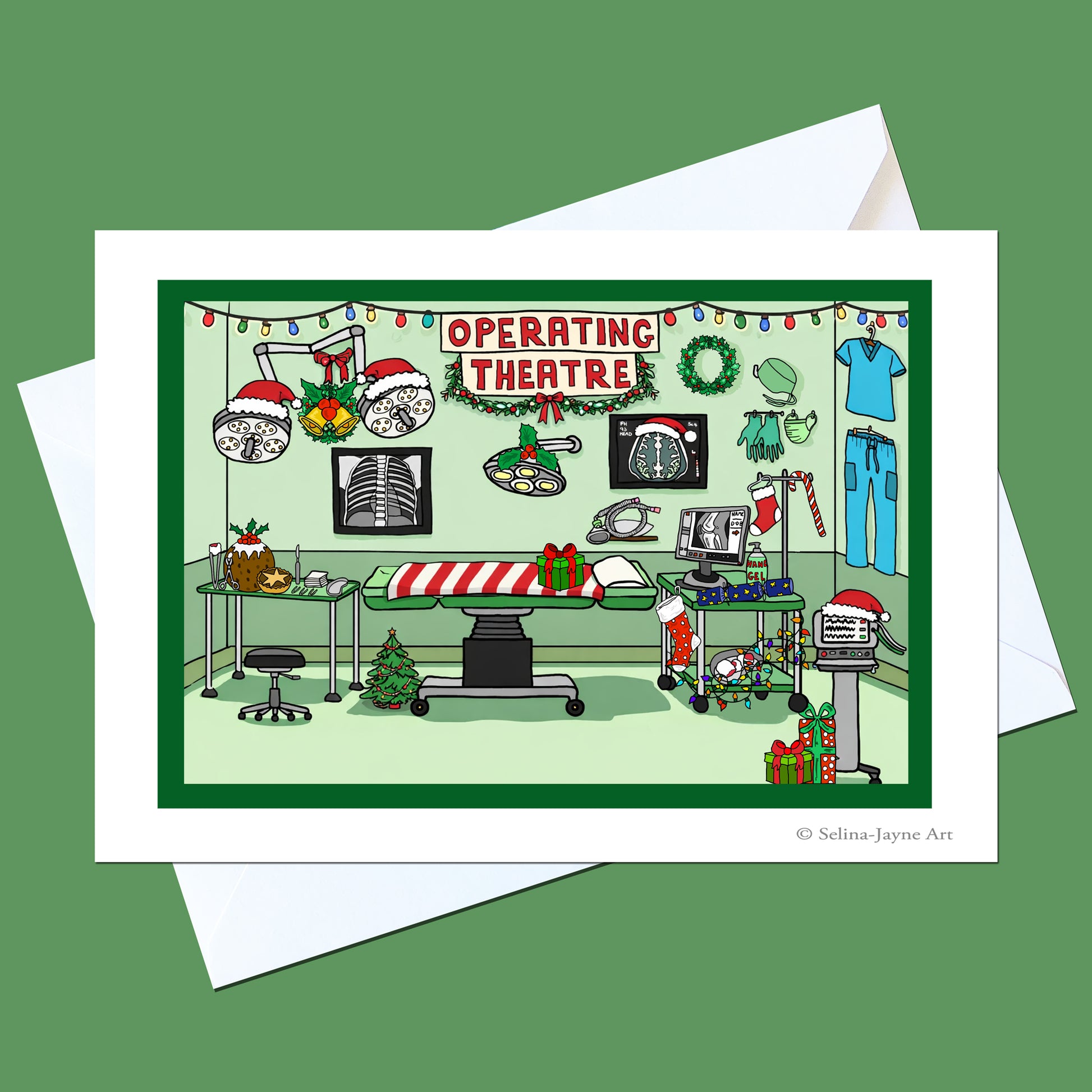 A Christmas-themed operating theatre art print on a white card, shown with white envelopes on a solid green background. The illustration features festive decorations like Santa hats, wreaths, and lights on a gurney, with medical equipment and a Christmas tree.