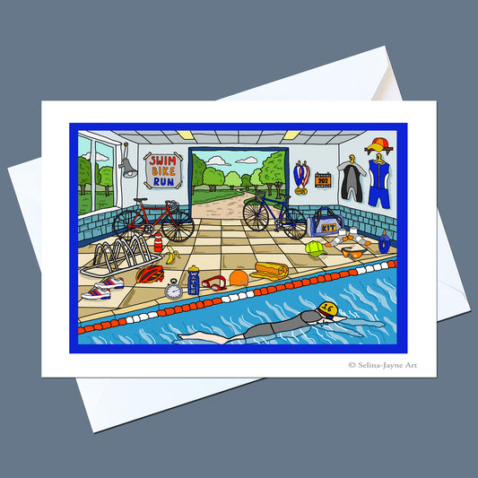 A square art print or greeting card featuring a colorful cartoon illustration of a swim station with bicycles, race medals, clothing, and a swimmer in the pool, shown on a white envelope against a dark gray background.