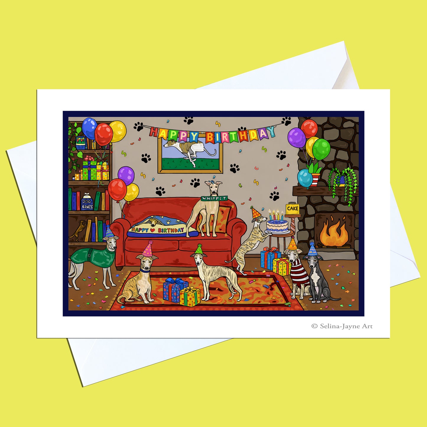 A square greeting card with a white border and white envelope, featuring a colorful cartoon illustration of dogs in a living room with balloons, a fireplace, and a 'HAPPY BIRTHDAY' banner, set against a pale yellow background.