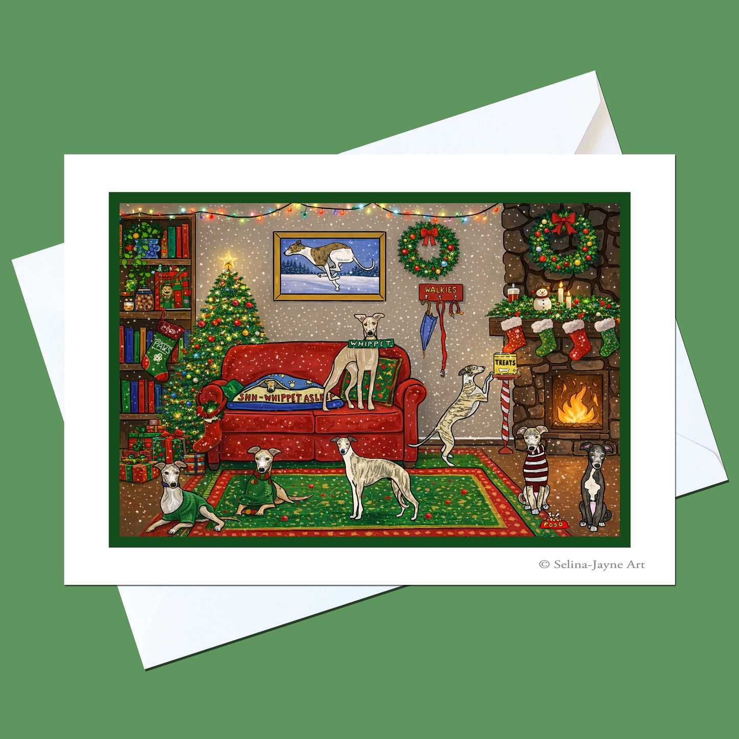 A holiday-themed art print featuring several dogs in a cozy living room decorated for Christmas, shown with a white envelope on a solid green background. The print has a white border and the artist's name 'Selina Jayne Art' is visible in the bottom right corner.